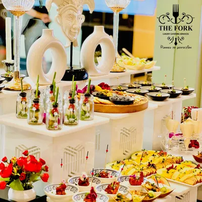A multi-tiered appetizer station showcasing a variety of canapés and small bites. The artistic decor elements and thoughtful arrangement highlight our philosophy of treating food presentation as an art form.