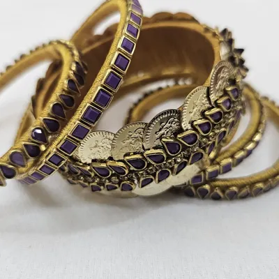 This regal purple bangle set features intricate kundan stone work and antique-style coins, perfect for adding a touch of royalty to your ethnic wear.
