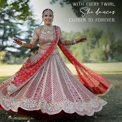 With every twirl, she dances closer to forever. This bride radiates joy in her traditional red Tarun Tahiliani lehenga, a look we curated to be both classic and full of life.