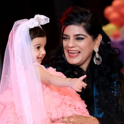 A beautiful candid moment between a mother and her daughter during a Disney-themed birthday party. These natural interactions are the heart of family function photography.