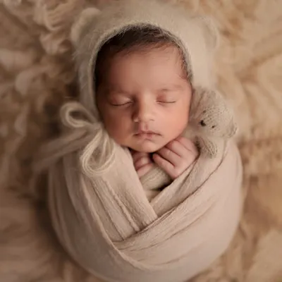 There's nothing sweeter than a baby in a bear bonnet. This cozy, neutral setup with a tiny teddy bear friend is a classic for a reason. It's all about capturing that innocent, sleepy perfection.