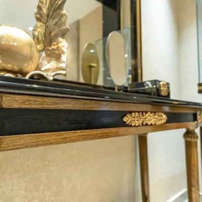 Craftsmanship is at the heart of my design philosophy. This close-up shows a handcrafted console table with intricate gold-leaf detailing and carved wooden elements, created to be a unique and personal piece for a client's luxurious living space.