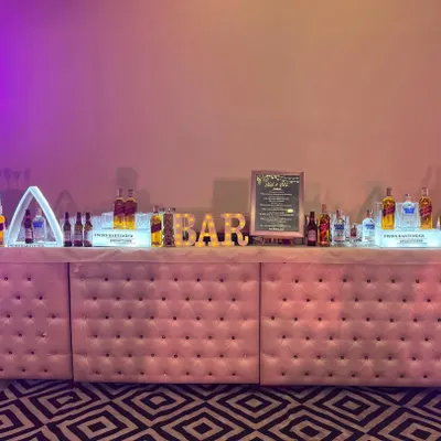 Our most popular setup: the pink tufted LED forming bar. This 16-foot bar is a true centerpiece, with customizable lighting and elegant design, perfect for weddings and grand celebrations.
