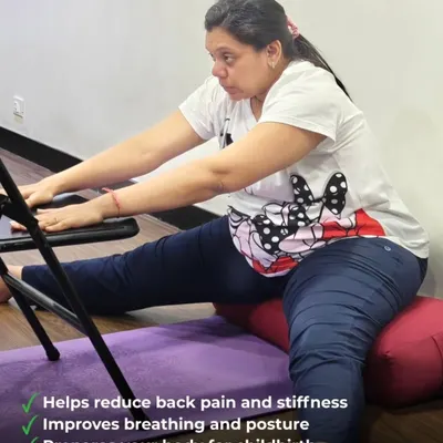 This supported forward bend, performed while seated on a bolster and using a chair, is excellent for relieving back pain and stiffness. It gently stretches the hamstrings and spine, improving posture and breathing.