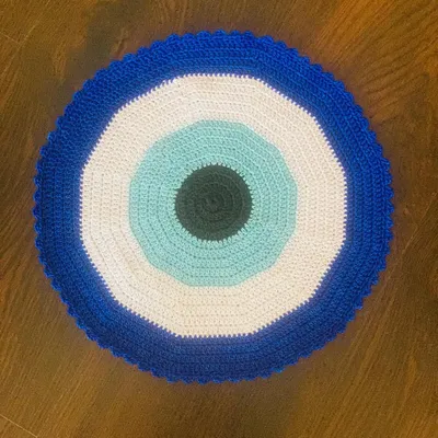 My crochet Evil Eye placemat is a modern and stylish piece meant to add good vibes to your home. The concentric circles of blue, white, and black are very striking.