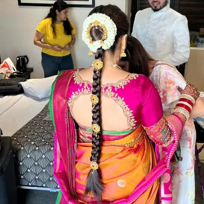 A stunning South Indian bridal braid, intricately woven and decorated with traditional gold ornaments and a fresh jasmine gajra. This hairstyle is the epitome of South Indian bridal beauty.