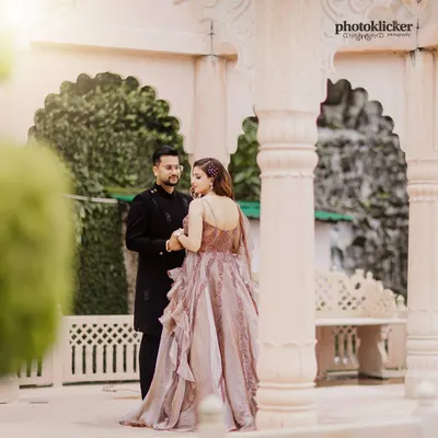 A beautifully lit portrait of a couple in elegant attire, standing within a classic stone gazebo, creating a timeless and romantic feel.