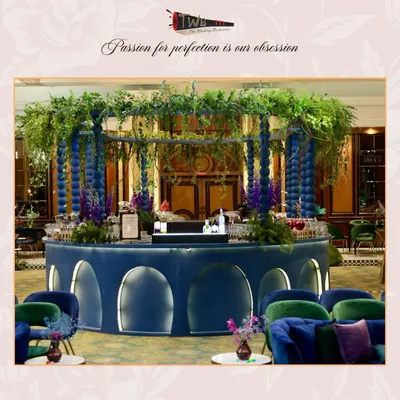 A breathtaking circular bar setup, adorned with lush greenery and florals, creating an immersive and luxurious atmosphere for a sangeet night at Taj Lands End.