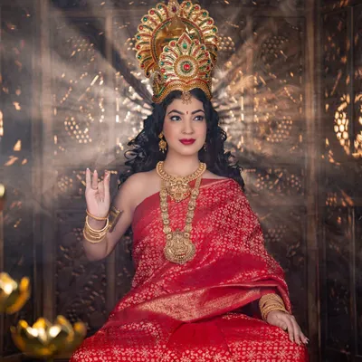 A powerful and divine look created for a Varamahalakshmi festival shoot. The makeup is regal, with bold red lips and defined eyes, complemented by a traditional crown and heavy gold jewellery to embody the goddess.