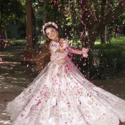 A magical shot from our Radha-themed photoshoot. The makeup is soft and ethereal, complemented by a shower of flower petals.