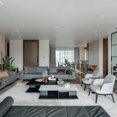 The main living area of the Sattva apartment was designed to be expansive yet welcoming. I used a combination of plush seating and a neutral color palette accented with dark wood to create a sophisticated space for social gatherings.