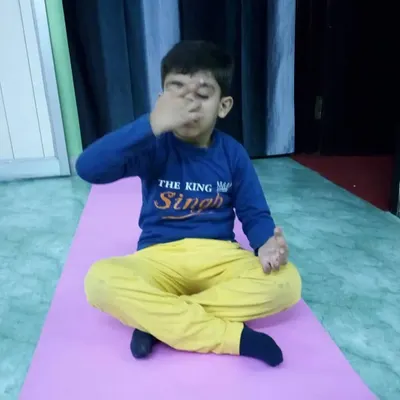 This young student is practicing Nadi Shodhana Pranayama, or alternate nostril breathing. Teaching children breathing techniques helps them calm their minds and improve focus.