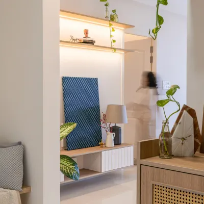 This apartment was designed for the rental market, so the moodboard had to be airy, subtle, and universal. This entryway nook features a simple shelf with integrated lighting and a rattan-finished cabinet, creating a welcoming first impression that can match any kind of furniture.