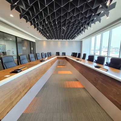 This conference room was designed for serious business. The custom U-shaped table encourages discussion, while the geometric acoustic ceiling is not just a design feature; it's crucial for sound management during important calls and meetings.