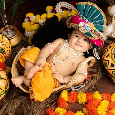 An absolutely adorable baby dressed as Little Krishna for Janmashtami. His joyful smile and playful pose in a basket make this photo truly special.