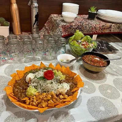 A full view of a healthy meal spread I prepared. The centerpiece is a loaded nacho platter, surrounded by fresh salad and salsa, showing how you can enjoy a feast that is both satisfying and nutritious.