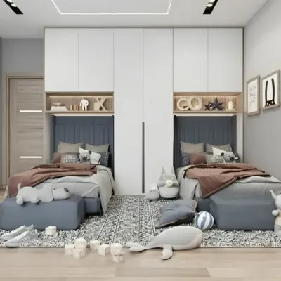This symmetrical design for a shared room provides each child with their own identical space, featuring a bed with a custom headboard niche and overhead storage cabinets.