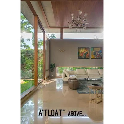 The living room ceiling appears to float above the walls, an architectural choice that enhances the feeling of height and openness in this Bengaluru home.