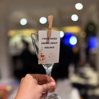 We love adding a bit of wit to our service. This custom glass tag, clipped on with a rustic clothespin, reads "I have mixed drinks about feelings," adding a playful touch that gets guests smiling.