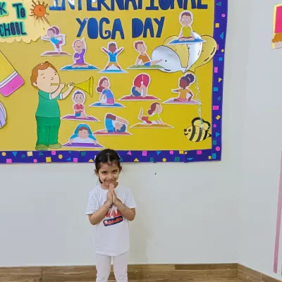 A little yogi in a 'namaste' pose on International Yoga Day. We introduce children to yoga early to promote flexibility, balance, and mindfulness.
