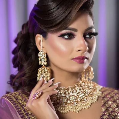 A perfect example of a glamorous reception look. The side-swept voluminous hair and dramatic makeup are ideal for an evening party.