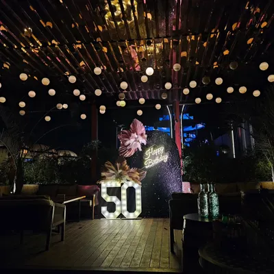 A stunning nighttime view of a 50th birthday bash I planned. The combination of the sequin wall, neon sign, marquee numbers, and overhead string lights created a truly magical and glamorous atmosphere.