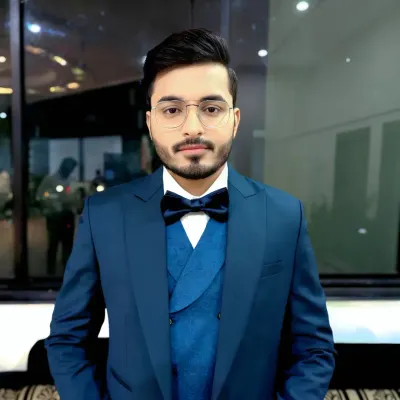 A classic, confident pose from a groom ready for his reception. The deep blue suit is complemented by a clean hairstyle and natural makeup that defines his features without being obvious.