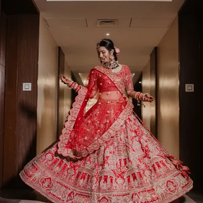 A breathtaking shot of the bride twirling in her magnificent red lehenga. We love creating these moments that showcase the beauty and grandeur of the bridal outfit.