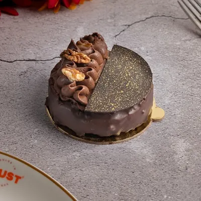 An example of my vegan indulgence, this individual chocolate pastry is rich and decadent. It features a half-moon of textured chocolate and is topped with chocolate cream and a walnut, proving that vegan desserts can be just as luxurious.