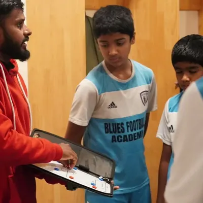 It all starts with a plan. Our licensed coach uses a tactics board to explain positional play to our youth team before a match. We focus on developing intelligent players who understand the game on a deeper level.