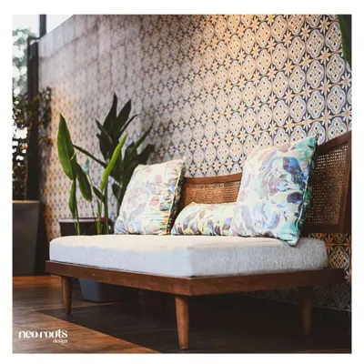 We created this cozy seating nook against a backdrop of beautiful Moroccan-style patterned tiles. The wooden bench with cane detailing and floral cushions adds a touch of bohemian charm, perfect for a quiet corner of a patio or balcony.