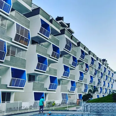The Mars Mount luxury apartment complex, featuring over 120 homes. The facade is defined by a rhythmic pattern of angled blue balconies, creating a visually striking exterior.