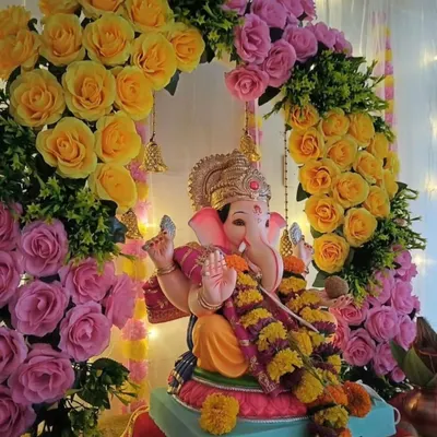 For Ganesh Chaturthi, we designed this beautiful floral backdrop for the Ganpati idol. The arrangement features a dense arch of yellow and pink roses with small bells, perfect for creating a sacred space for worship.