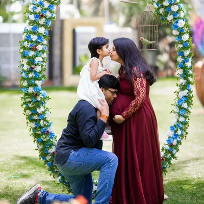 A perfect family portrait full of love and anticipation. This pose, with the daughter on her father's shoulders kissing her mom, is a beautiful way to include siblings in the maternity journey.