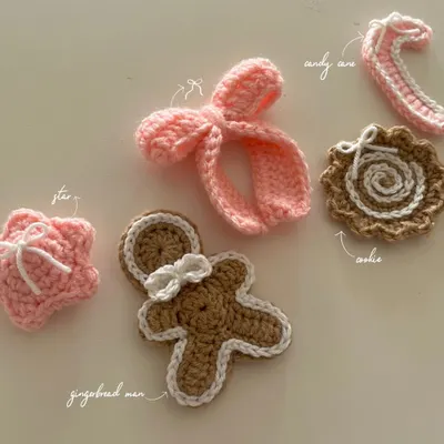 An overview of my handmade Christmas collection. It includes a gingerbread man, a swirl cookie, a candy cane, and a puffy star and bow in festive pink.