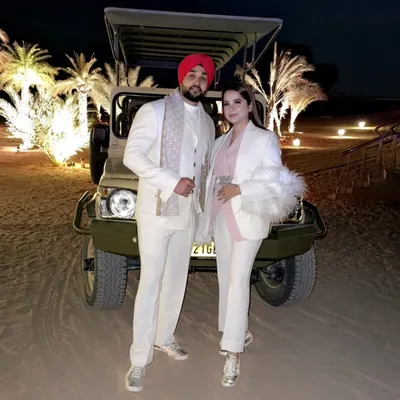 A power couple dressed in custom all white outfits for a special occasion in the desert. I designed his look with a classic bandhgala jacket and tailored trousers, creating an elegant and coordinated style.