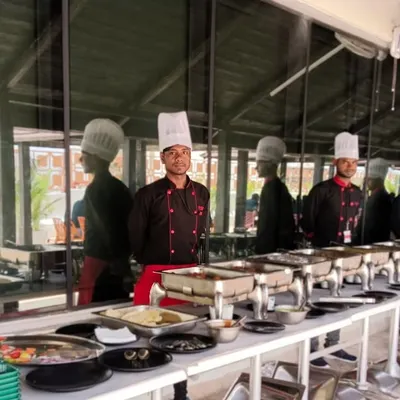 A full buffet line ready for a corporate lunch at IQVIA. Our team stands ready to serve, ensuring every dish from salads to main courses is perfectly presented.