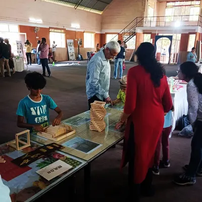 We love seeing multiple generations building together. Here, a grandfather offers his wisdom while a child and parent work on their structure. Our workshops are truly a family affair, creating a space for shared learning and bonding across all ages.