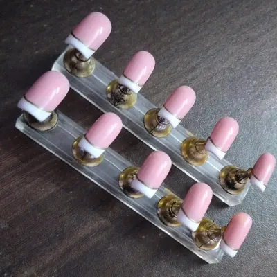 A modern take on the classic French manicure. This set features a soft pink base with a crisp white tip, accented by a thin, elegant gold line for a touch of luxury.