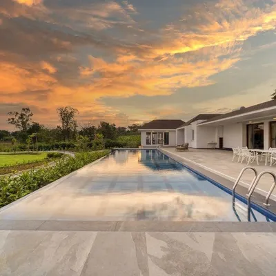 For this farmhouse by the backwaters, the infinity pool and patio are positioned to capture breathtaking views. The landscape design ensures an uninterrupted reflection of the sky, making the pool a tranquil mirror of the natural surroundings.