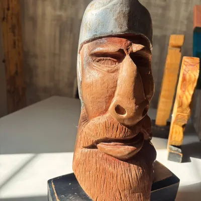 A story told in grain and groove. This hand-carved wooden bust, with its weathered expression and detailed texture, is filled with quiet strength.