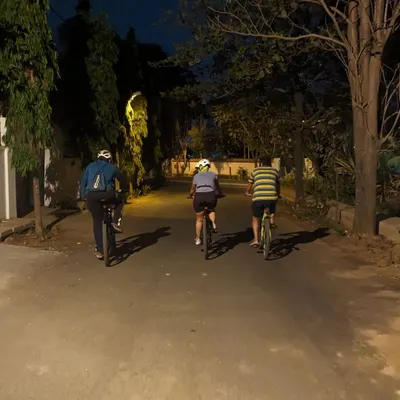 Three of us cycling down a quiet, tree-lined road in old Whitefield. This is the essence of our rides: peaceful, conversational, and surrounded by the calm of the night.