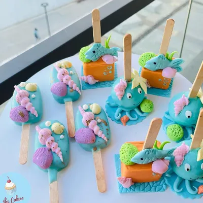 A closer look at my custom cakesicles, designed here for a mermaid-themed party. Each one is a small work of art, decorated with edible seashells, octopuses, and fish to delight your guests.