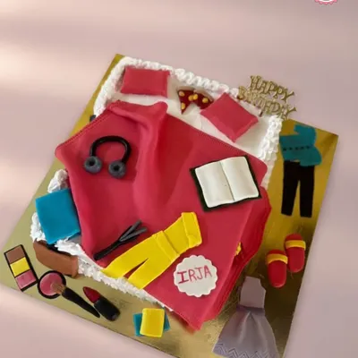 This cake was designed for someone with many passions. It features edible fondant creations representing makeup, books, music, and fashion, all arranged on a cake shaped like a folded shirt. It’s a great example of a truly personalized design.