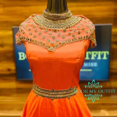 This custom-made orange gown is designed for parties and special events. It features an intricately hand-beaded illusion neckline and a matching belt, creating a sophisticated silhouette that is tailored to your measurements.