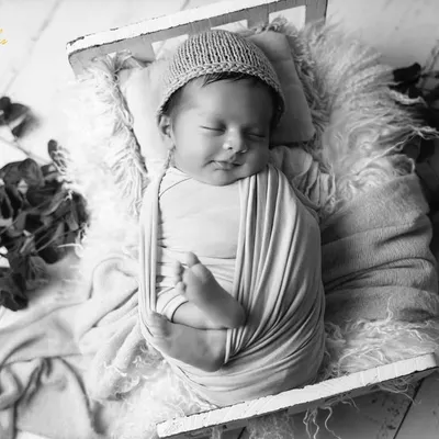 This swaddled baby looks so peaceful in black and white. The monochrome conversion emphasizes the soft textures of the wrap and the serene expression on the baby's face.