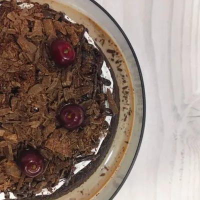 An aerial view of my Black Forest Tres Leches cake. This shows the rich chocolate shavings and fresh cherries that top the moist, chocolate-soaked sponge, promising a decadent experience.