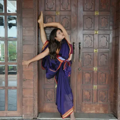 I practiced yoga in a saree today at a stunning ranch. This standing split, or Urdhva Prasarita Eka Padasana, shows that yoga doesn't need perfect clothes, just presence.