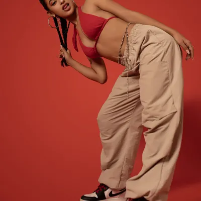 A dynamic pose against a bold red background. This shot captures the urban and edgy side of my style, blending dance and fashion.
