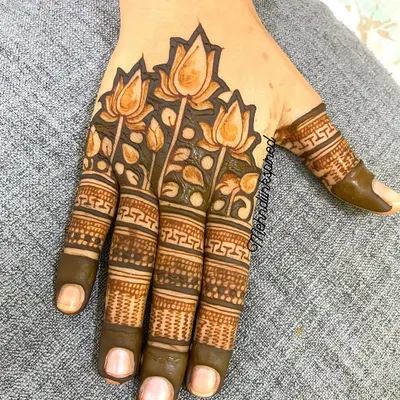 For the lover of minimal henna, this design features a beautiful band of lotus flowers across the back of the hand. The fingers are detailed with geometric bands, leaving the palm open.